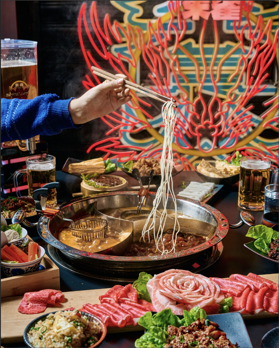 Cooking noodles in split pot surrounded by the cyberpunk interior of YX Hotpot, Melbourne CBD