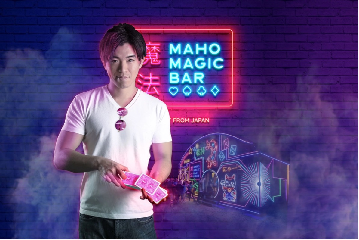 Magician performing card tricks inside the neon-lit Maho Magic Bar at Spiegel Haus Melbourne.
