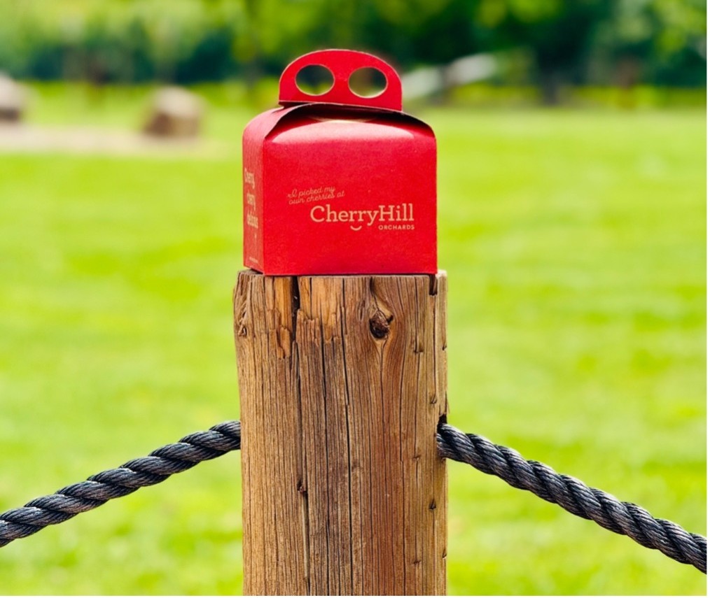 CherryHill Orchards "Sweet Cheeks" cherry gift boxes on display in front of farmgate fridge