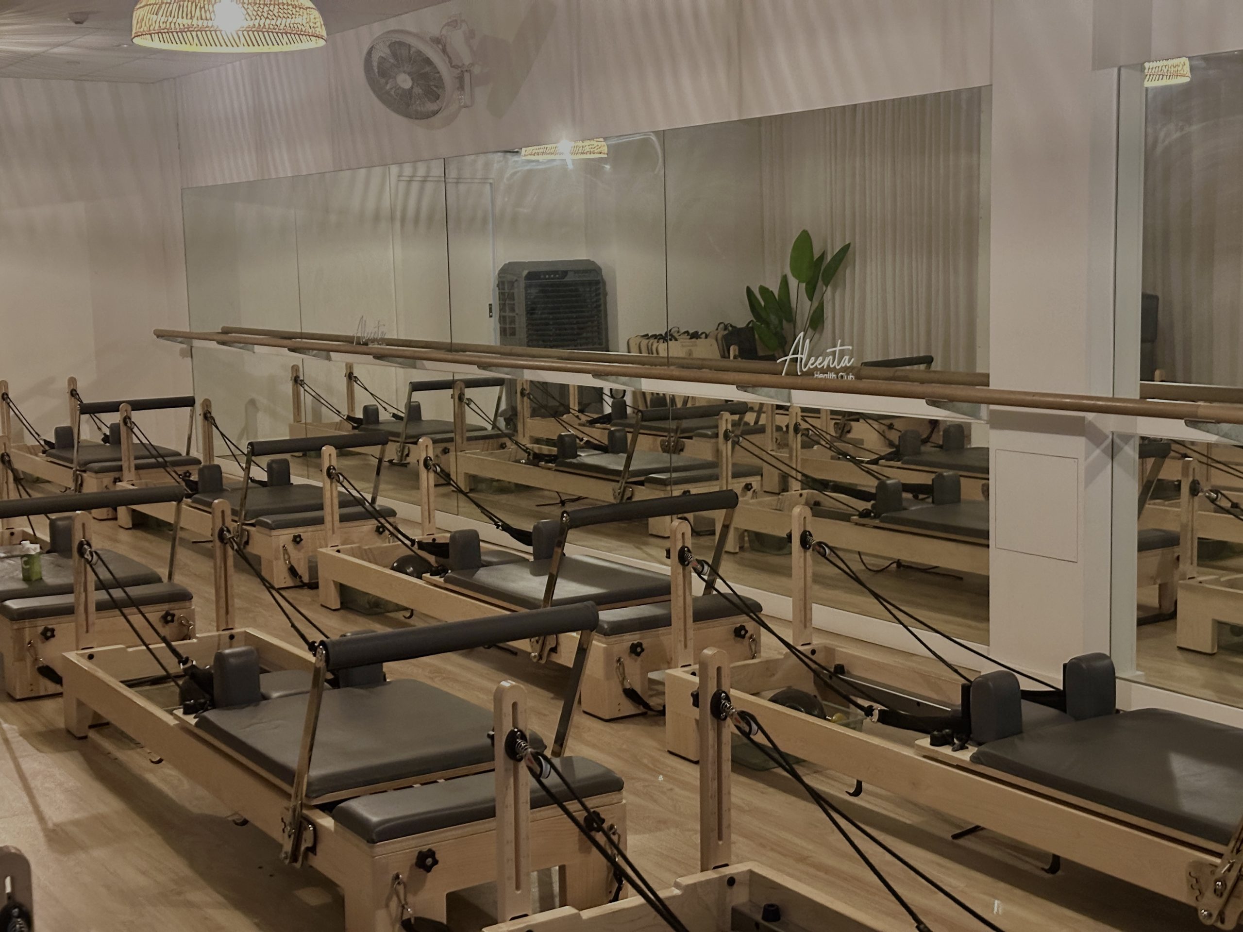 A studio room of reformer pilates machines at Aleenta Health Club Bourke St