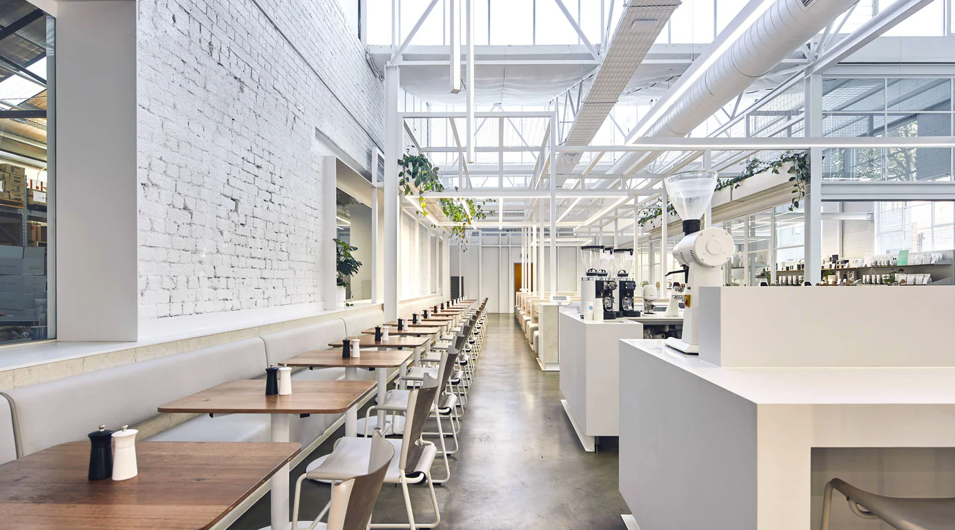 Interior of Industry Beans showcasing its bright, white minimalist design and long café seating.