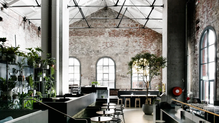 Interior of Higher Ground featuring exposed brick walls, high ceilings and large arched windows