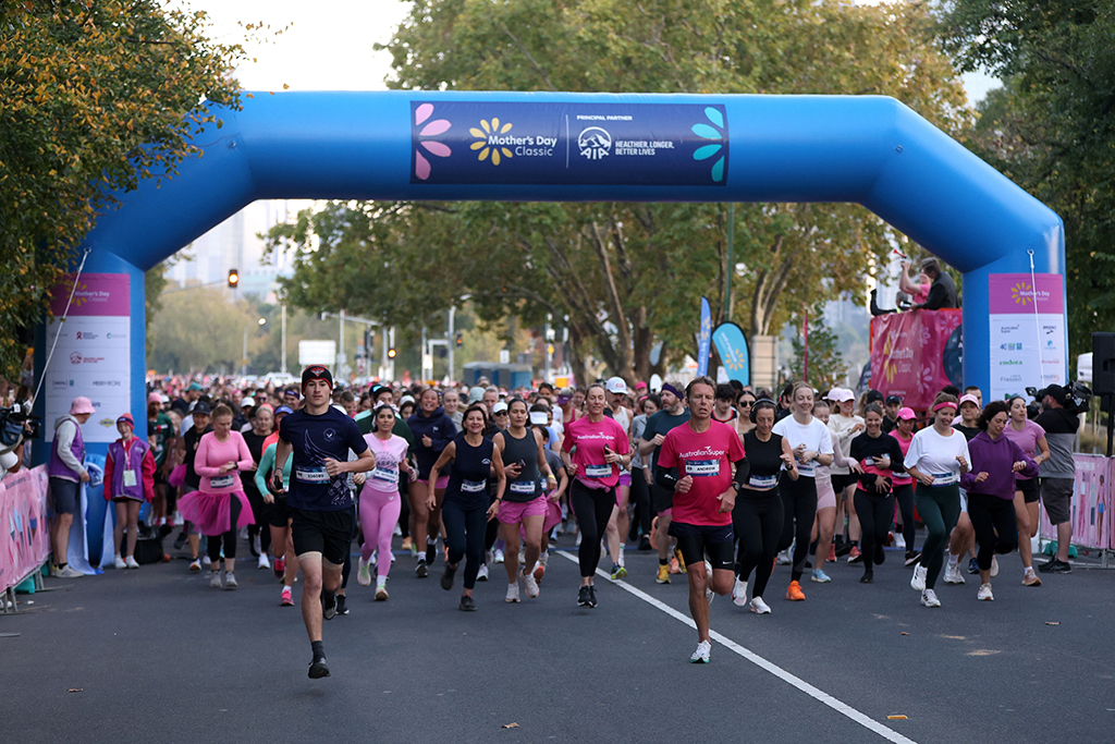 Participants running under the start line arch at the Mother's Day Classic Melbourne Alexandra Gardens