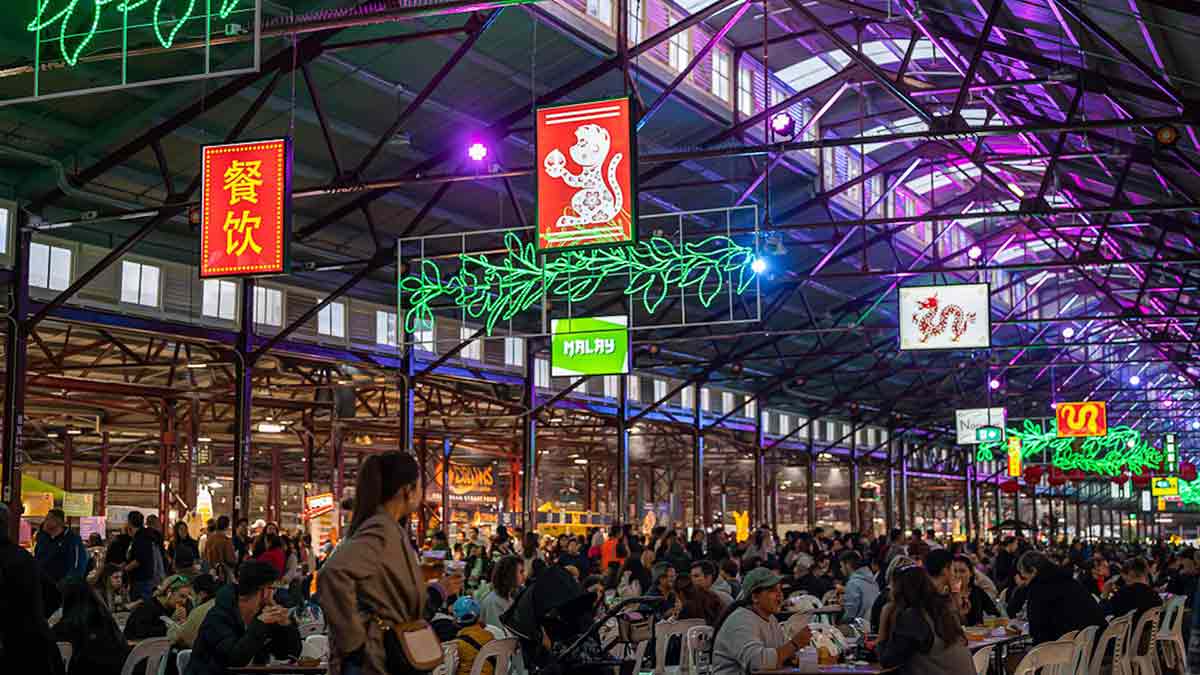 Hawker 88 Night Market Queen Victoria Market Melbourne indoor sheds with neon lights lanterns and communal dining tables