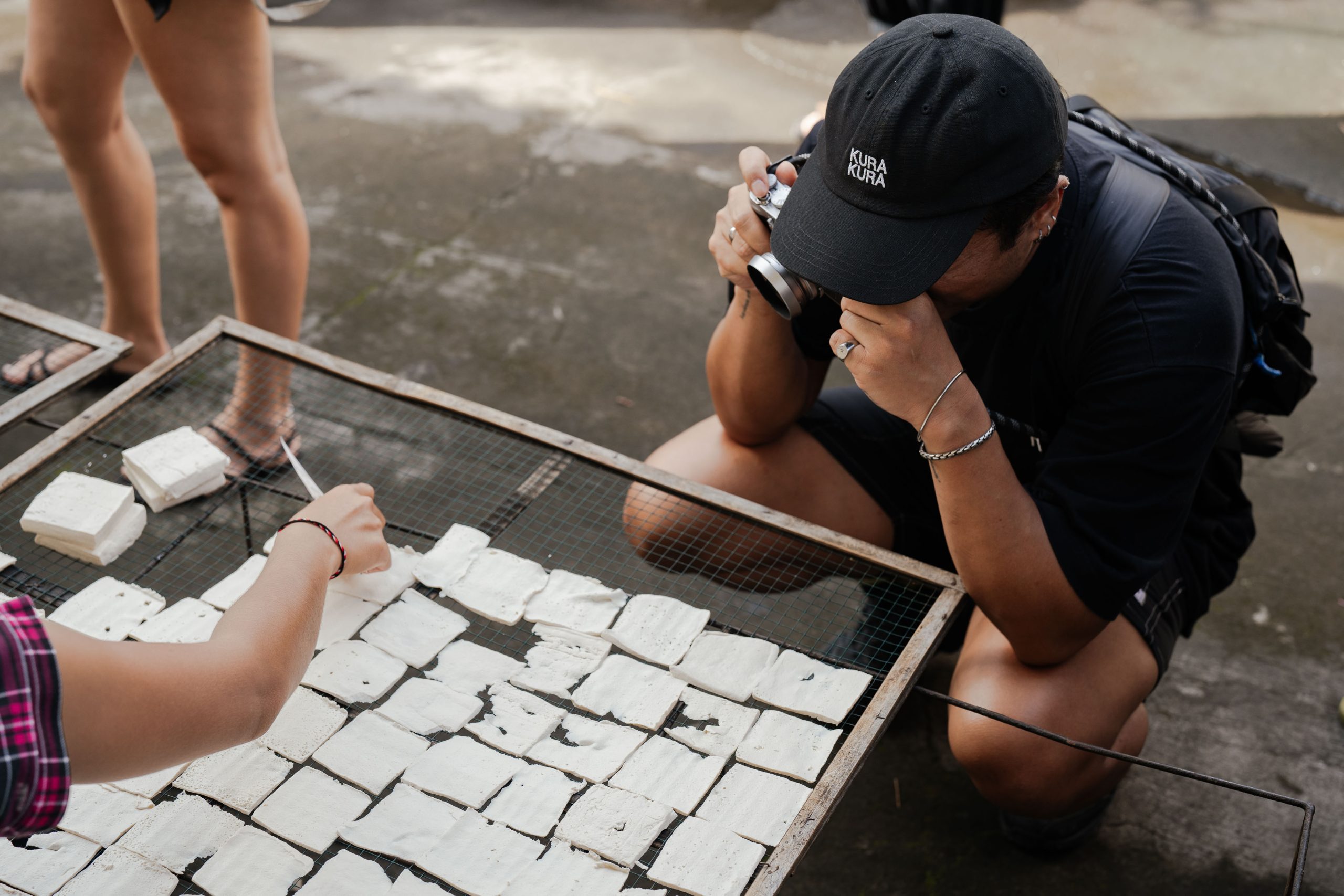 Food tour participant photographing traditional tofu making process on Ubud Food Festival 2026 Jalan Jalan Makan food tour Bali