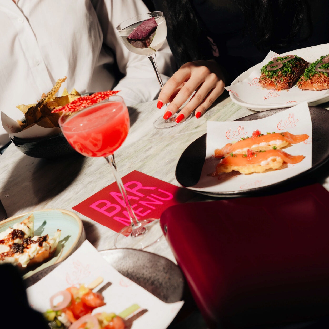 Sharing plates and cocktails on the table at JUNI, fire-and-spice Southeast Asian dining restaurant in Melbourne CBD