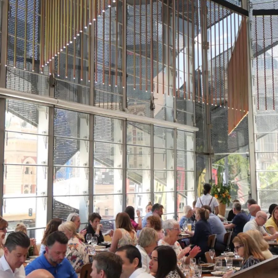 Busy lunch service at Taxi Kitchen Federation Square Melbourne with floor-to-ceiling windows and panoramic city views